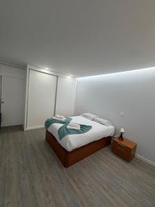 a white room with a bed and a night stand at Dream House in Aldeia Nova