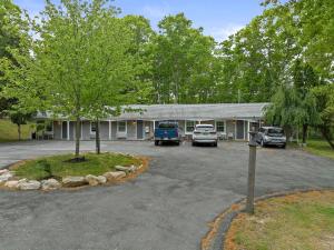 a building with cars parked in a parking lot at Sandwich Inn and Suites in Sandwich