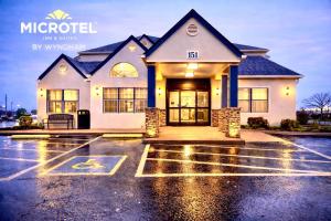 a house in a parking lot in the rain at Microtel Inn by Wyndham - Murfreesboro in Murfreesboro