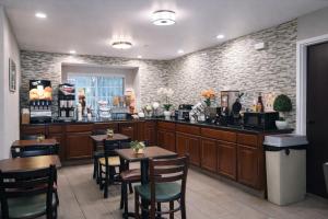 a restaurant with tables and chairs and a bar at Microtel Inn by Wyndham - Murfreesboro in Murfreesboro
