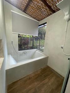 a white bath tub in a bathroom with a window at Jeribucaçu bangalô in Itacaré