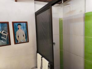 a bathroom with a shower and a painting of a man at Chalé de montaña con Jacuzzi in Guarne +8 photos