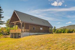 a large wooden house on top of a field at Mountain-View Deck! Cabin By Mt Abraham Trails in Kingfield