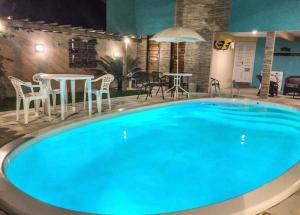 a large blue swimming pool with tables and chairs at Pousada Inn Blue Horizon in Porto De Galinhas +40 photos