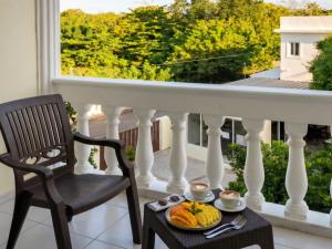 ein Tisch mit einer Obstschale und einem Stuhl auf einem Balkon in der Unterkunft Costambar in San Felipe de Puerto Plata