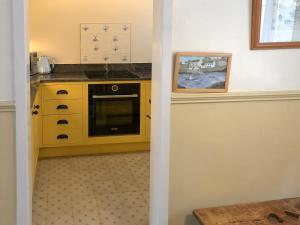 a kitchen with a yellow cabinet and a microwave at The Anchorage in Staithes