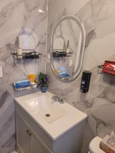 a bathroom with a sink and a mirror at Downtown apartment next to highway netflix+wifi in Edmundston +39 photos