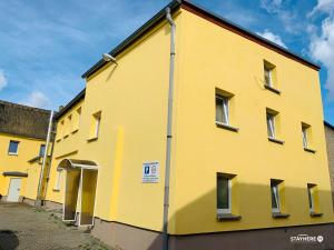 a yellow building with a no parking sign on it at StayHere24 Große Monteur- und Ferienwohnung am Auenwald in Schkeuditz