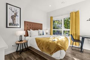 a bedroom with a bed and a desk and a window at Cloudline Vista 3 BdrmTownhouse w Private Garage Views Pool Walk Downtown in Canmore