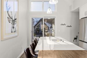 a kitchen with a white counter and a sink at Cloudline Vista 3 BdrmTownhouse w Private Garage Views Pool Walk Downtown in Canmore