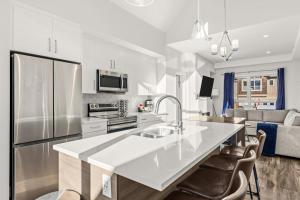 a kitchen with a large white counter top in a room at Cloudline Vista 3 BdrmTownhouse w Private Garage Views Pool Walk Downtown in Canmore +33 photos