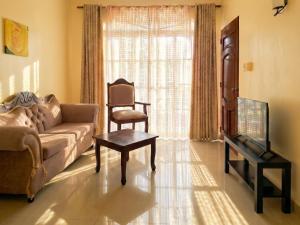 ein Wohnzimmer mit Sofa, Sessel und Fernseher in der Unterkunft Costambar in San Felipe de Puerto Plata