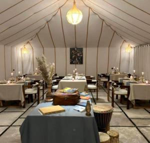 a large tent with tables and chairs in it at Starry Nights Camp in Merzouga