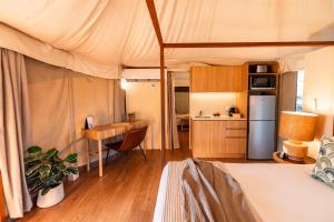 a bedroom with a bed and a kitchen with a table at Ingenia Holidays Rivershore in Maroochydore