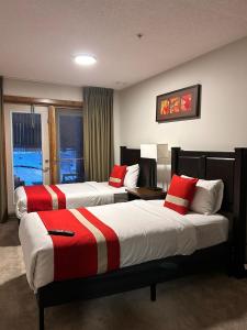 a hotel room with two beds with red and white pillows at Spacious, Pet Friendly, Townhouse Hot Tub Perfect for Families! in Canmore