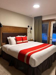 a bedroom with a large bed with red and white pillows at Spacious, Pet Friendly, Townhouse Hot Tub Perfect for Families! in Canmore