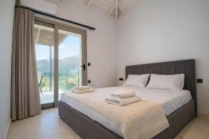 a bedroom with a large bed with towels on it at Saint Helen Villas in Parga