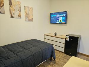 a bedroom with a bed and a tv on the wall at Apartamentos TerraLoft in San Antonio