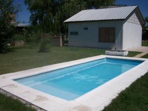 a swimming pool in a yard with a house at Capibara Matero in Roldán