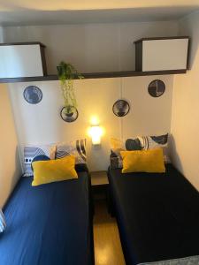 two beds with yellow pillows in a room at Sunset Lagoon House in Lagoa