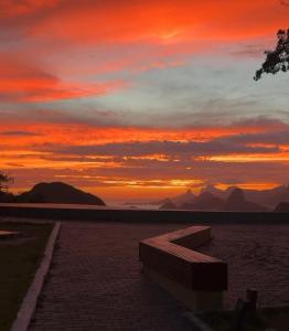 a bench sitting in front of a sunset at Sou mais Icarai in Niterói