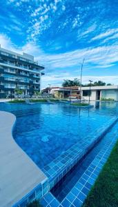 a swimming pool with blue water in front of a building at Sou mais Icarai in Niterói