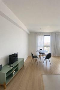 a living room with a tv and a table and chairs at Sou mais Icarai in Niterói
