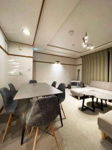 a room with a table and chairs and a couch at 呼人2 Arun別邸 in Abashiri