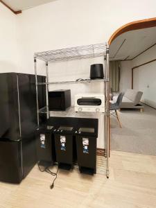a living room with a black refrigerator and a kitchen at 呼人2 Arun別邸 in Abashiri