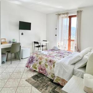 a bedroom with a bed and a desk and a window at La Villa Carmelina in Agerola
