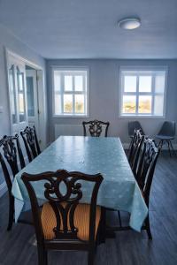 a dining room with a blue table and chairs at Aran View Holiday Homes Doolin - The Atlantic Stone House - Ocean Views in Doolin