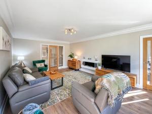 a living room with two couches and a flat screen tv at Casa Rosa in Prestatyn
