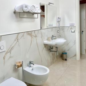 a white bathroom with a sink and a toilet at La Villa Carmelina in Agerola