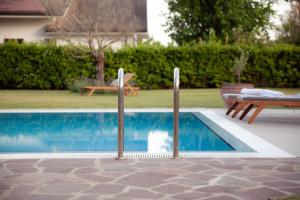 a swimming pool in a yard with a table and a bench at Villa Helena, Venetien, Exklusive Villa auf Privatinsel Albarella, 4 Bedrooms 8 Personen, 300 m Strand in Isola Albarella