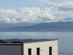 a building with solar panels on it next to the water at Penthouse Seeblick Wohnung 86 qm KLIMATISIERT in Friedrichshafen