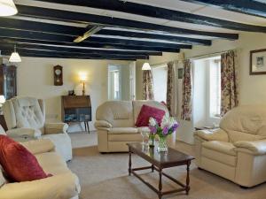 a living room with couches and chairs and a table at Ty Cornel in Aberporth
