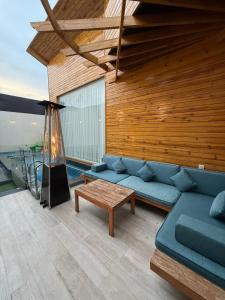 a living room with a blue couch and a table at اكواخ سنتارا الريفيه in Taif