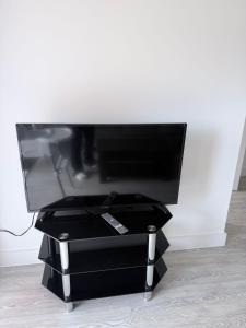 a flat screen tv sitting on a black stand at Peaceful and stylish apartment near Cambridge with parking in CBG