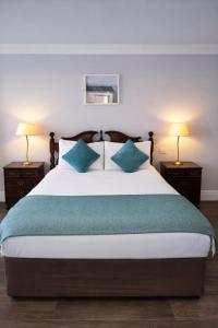 a bedroom with a large bed with blue pillows at Aran View Holiday Homes Doolin - The Atlantic Stone House - Ocean Views in Doolin +6 photos