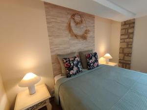 a bedroom with a blue bed and two lamps at Maisonnette provençale les pensées in Carpentras +6 photos