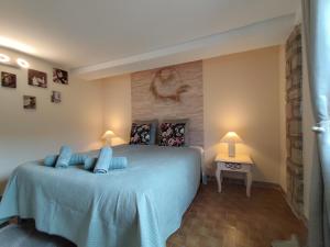 a bedroom with a bed with blue pillows on it at Maisonnette provençale les pensées in Carpentras