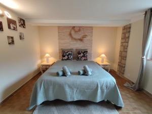 a bedroom with a bed with two pillows on it at Maisonnette provençale les pensées in Carpentras