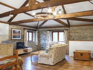 a living room with a chair and a tv at The Hayloft - Uk50027 in Liskeard
