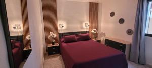a bedroom with a bed with red sheets and red pillows at EL Gecko in Alcossebre