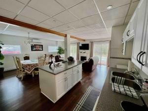 a kitchen and living room with a table in it at Pet Friendly Licensed Suite on Haskap Farm in Kelowna