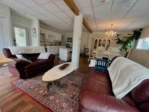 a living room with two couches and a table at Pet Friendly Licensed Suite on Haskap Farm in Kelowna