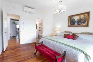 a bedroom with a large bed with a red bench at Pet Friendly Licensed Suite on Haskap Farm in Kelowna +18 photos