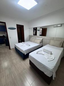 a hotel room with two beds and a mirror at Elegance Residences Cumbuco in Cumbuco