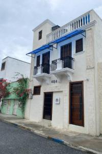 a white building with a blue roof and windows at CEDOTURT Hotel Boutique & Escuela in Santo Domingo