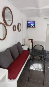 a living room with a couch and a table and a tv at Bungalow Josefina flores in Lo de Marcos
